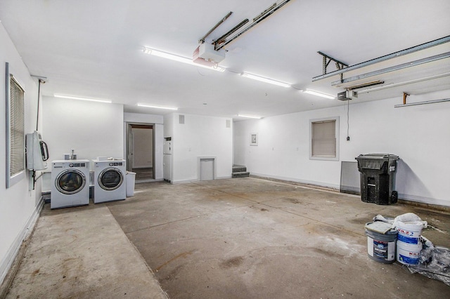 garage with baseboards, washer and clothes dryer, and a garage door opener