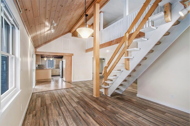 interior space featuring wood ceiling, baseboards, wood finished floors, and high vaulted ceiling