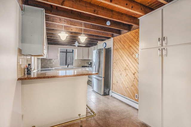 kitchen featuring wooden ceiling, beamed ceiling, freestanding refrigerator, a baseboard heating unit, and white cabinetry