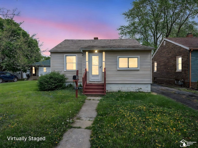 bungalow with a lawn and entry steps