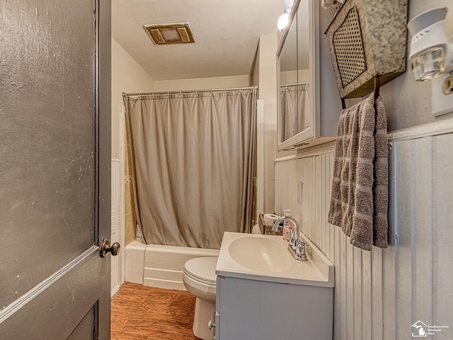 bathroom featuring visible vents, wood finished floors, vanity, toilet, and shower / bath combo with shower curtain