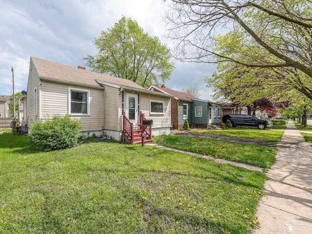 view of front of house with a front lawn, a chimney, and entry steps