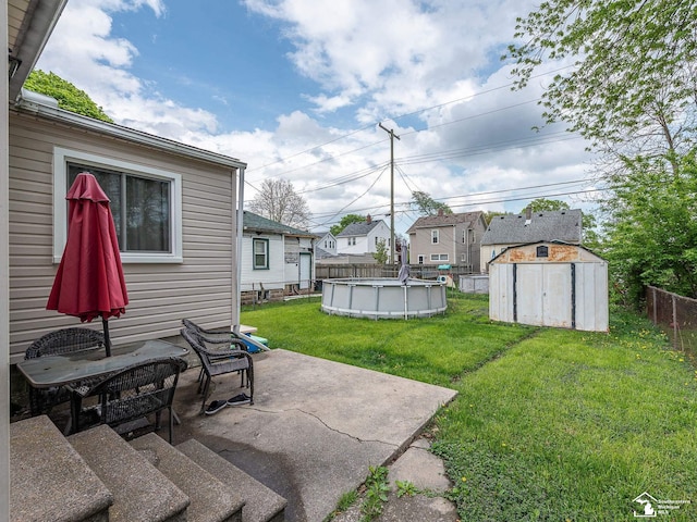 view of yard featuring an outdoor structure, a patio, a fenced backyard, a fenced in pool, and a storage shed