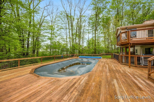 view of swimming pool featuring a hot tub and a wooden deck