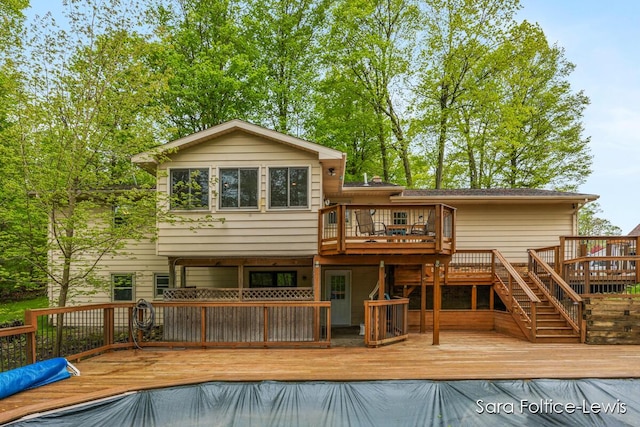 rear view of property with a deck and stairs