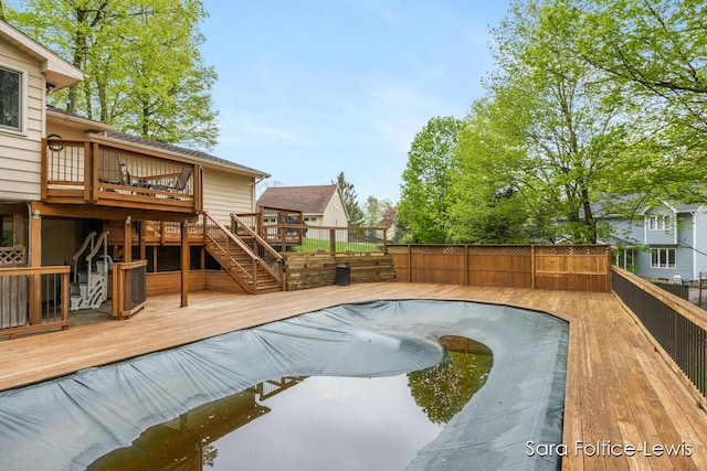 view of pool featuring stairway, a wooden deck, a fenced backyard, and a fenced in pool