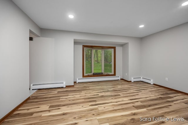 spare room featuring baseboard heating, recessed lighting, and wood finished floors