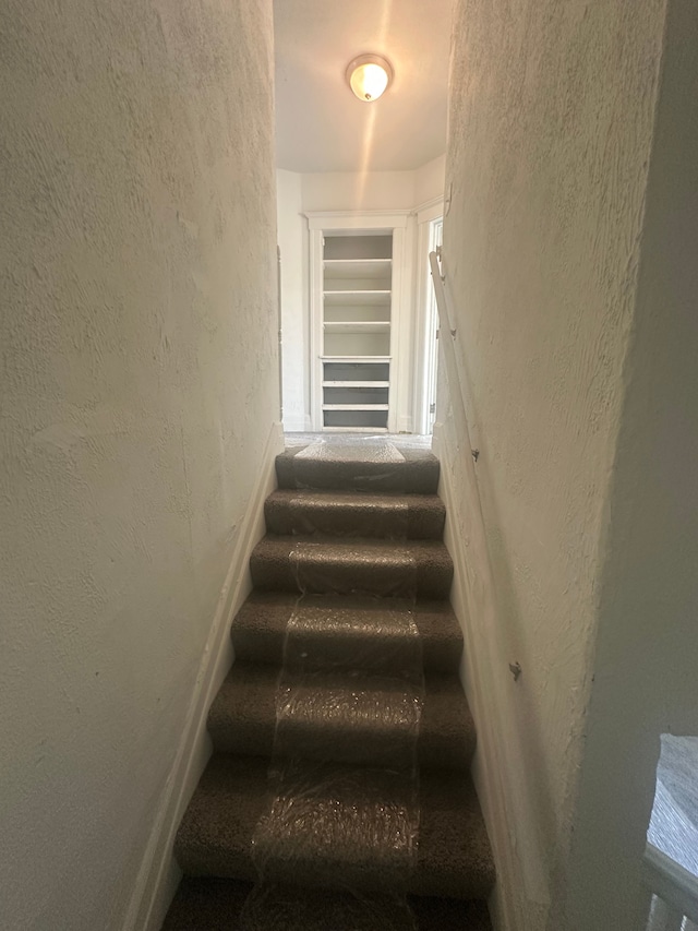 staircase with a textured wall