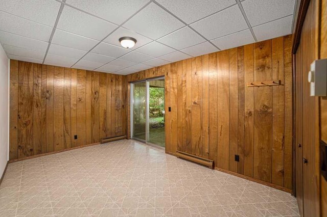 410 Orchard Ct, Saint Louis, MI 48880 - spare room featuring a drop ceiling, light floors, and wooden walls