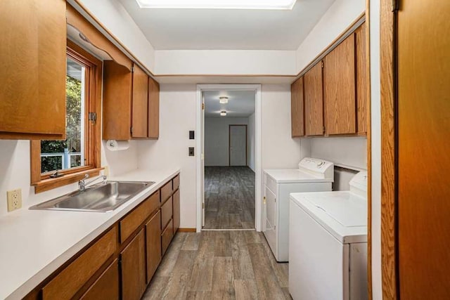 410 Orchard Ct, Saint Louis, MI 48880 - clothes washing area with a sink, cabinet space, separate washer and dryer, baseboards, and light wood-style floors