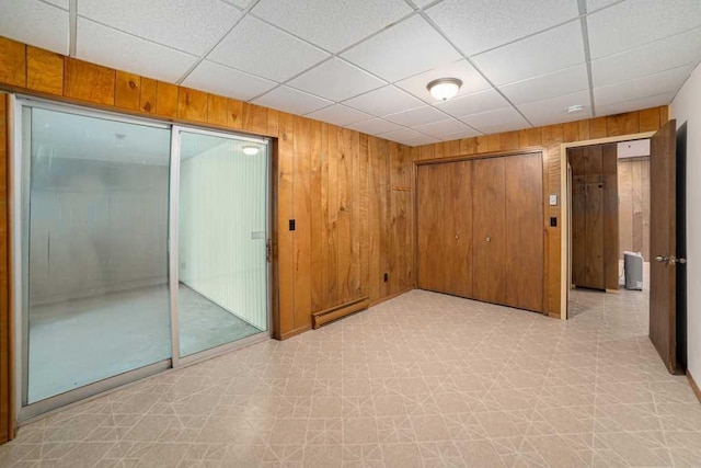 410 Orchard Ct, Saint Louis, MI 48880 - unfurnished room featuring a paneled ceiling, light floors, and wood walls