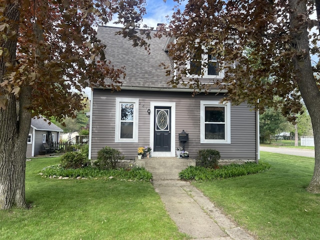 bungalow with a shingled roof and a front yard