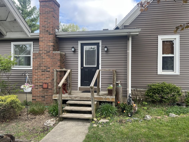 property entrance with a chimney and a deck