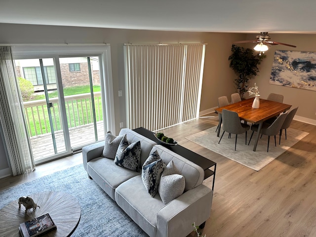 living room with wood finished floors, ceiling fan, and baseboards