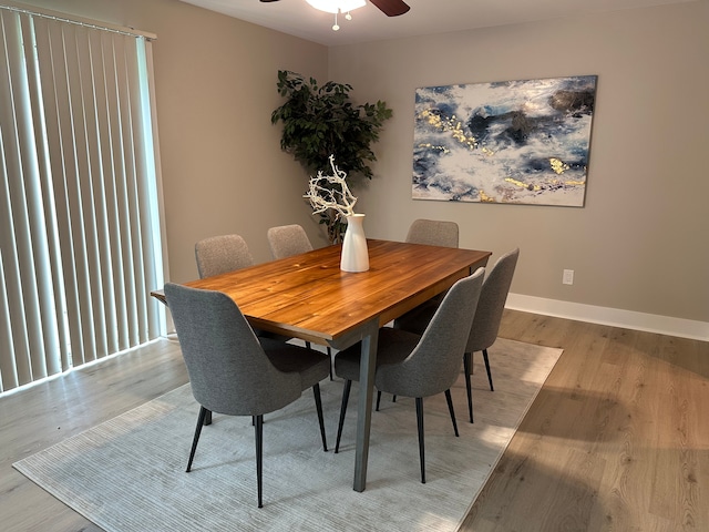 dining space with a ceiling fan, light wood-style flooring, and baseboards