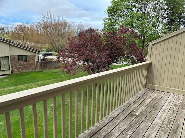 wooden terrace featuring a lawn