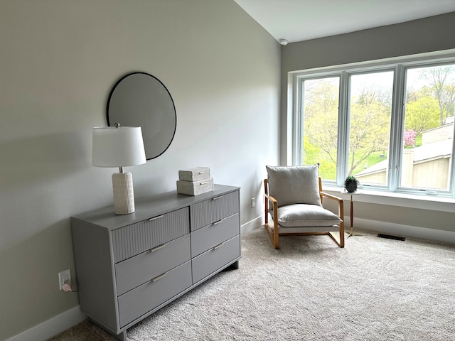 living area featuring baseboards and light carpet