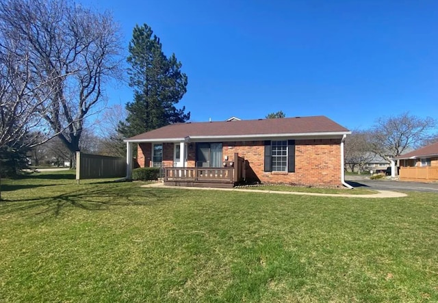 view of front of property with brick siding, a wooden deck, and a front lawn