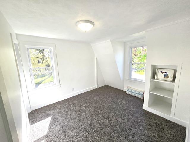 unfurnished room featuring dark carpet