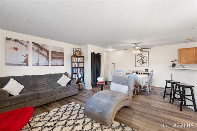 living area with a ceiling fan and wood finished floors
