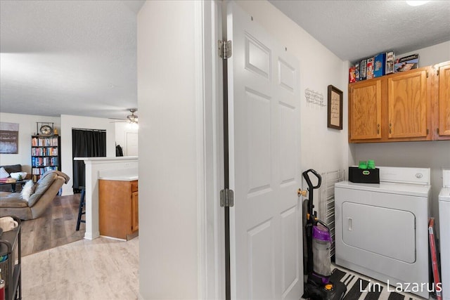 laundry area with cabinet space, washer and dryer, ceiling fan, a textured ceiling, and light wood-type flooring