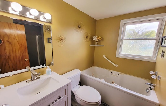 bathroom with vanity, toilet, and a tub with jets