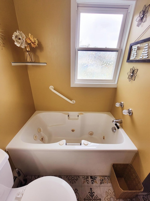 bathroom featuring toilet, tile patterned flooring, and a whirlpool tub