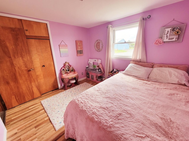 bedroom with a closet, baseboards, and wood finished floors
