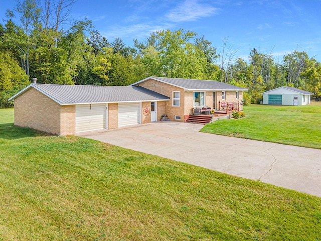 view of front of house with driveway, metal roof, a front yard, brick siding, and an attached garage