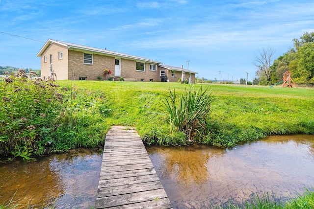 view of dock with a lawn