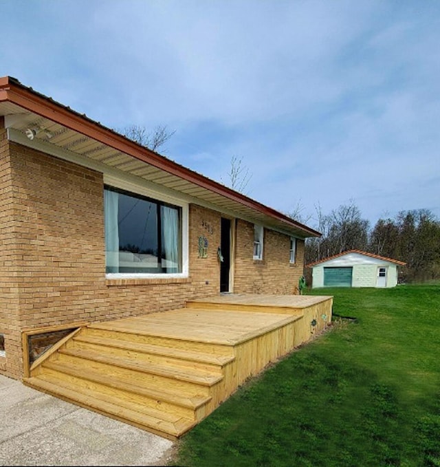 rear view of property with a yard, brick siding, and a wooden deck