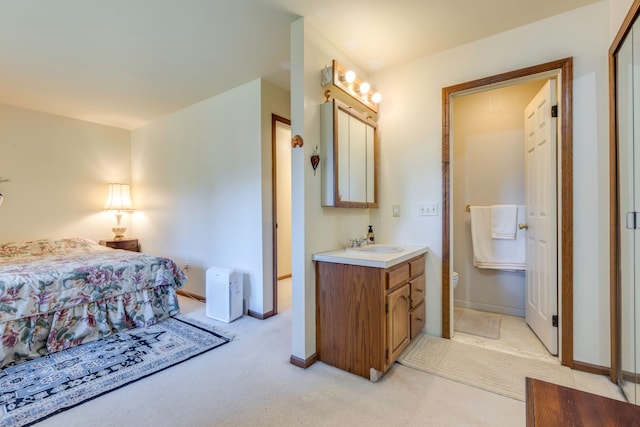 bedroom with baseboards, light carpet, and a sink