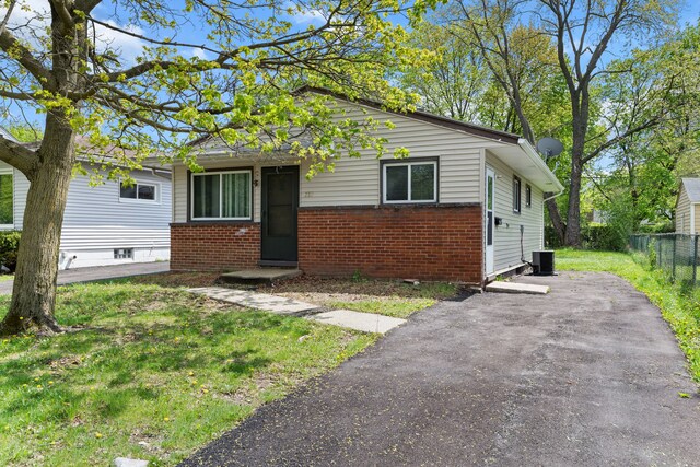 289 Nebraska Ave, Pontiac, MI 48341 - view of front of property featuring brick siding, central AC unit, a front lawn, and fence