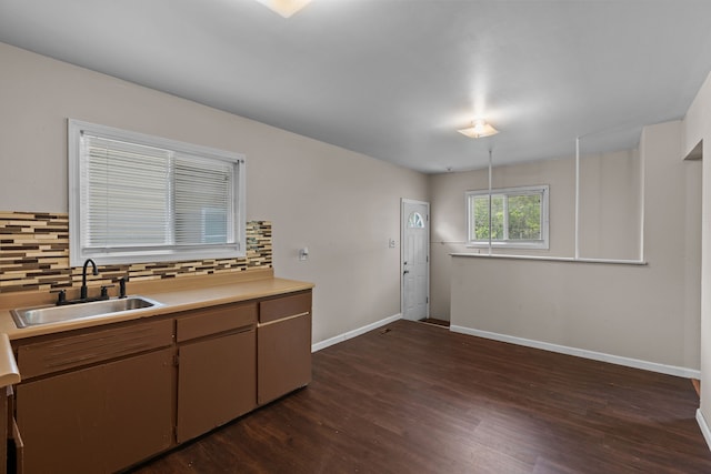 289 Nebraska Ave, Pontiac, MI 48341 - kitchen with decorative backsplash, a sink, baseboards, light countertops, and dark wood-type flooring