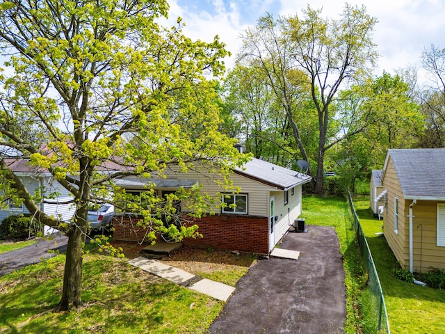 289 Nebraska Ave, Pontiac, MI 48341 - view of front facade with central air condition unit, brick siding, a front lawn, and aphalt driveway