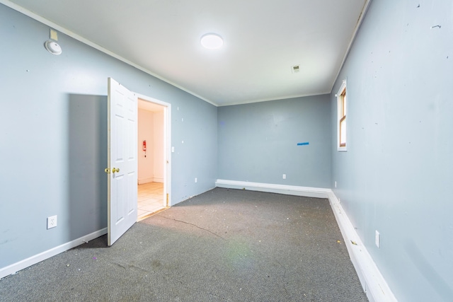 carpeted empty room featuring baseboards
