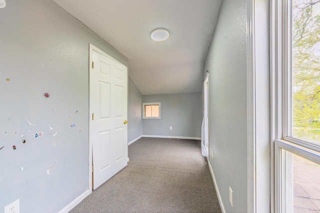 hallway featuring carpet floors and baseboards