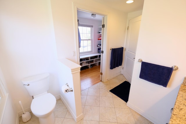 bathroom with baseboards, recessed lighting, tile patterned floors, and toilet