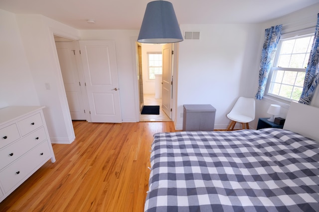 bedroom featuring visible vents, light wood-style floors, and baseboards