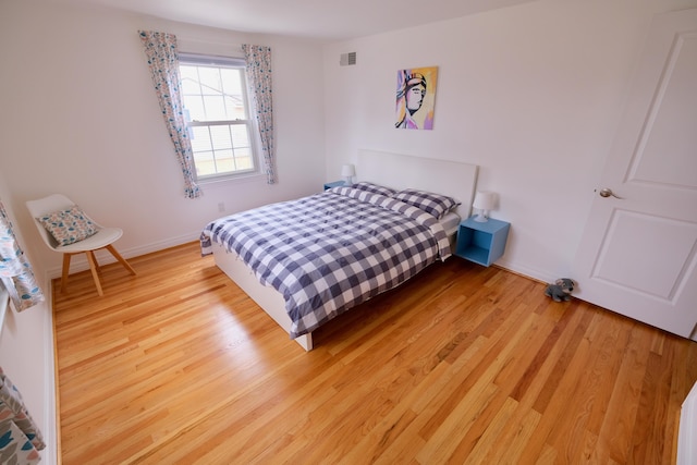 bedroom with baseboards, visible vents, and light wood-style floors