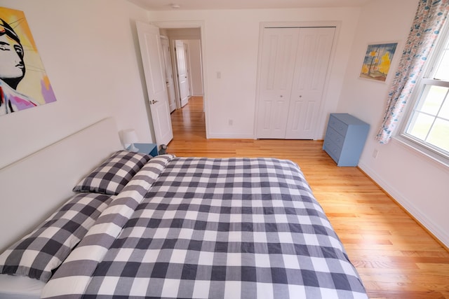 unfurnished bedroom featuring baseboards, a closet, and wood finished floors