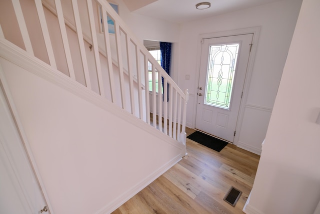 foyer featuring light wood-style floors, stairs, and visible vents