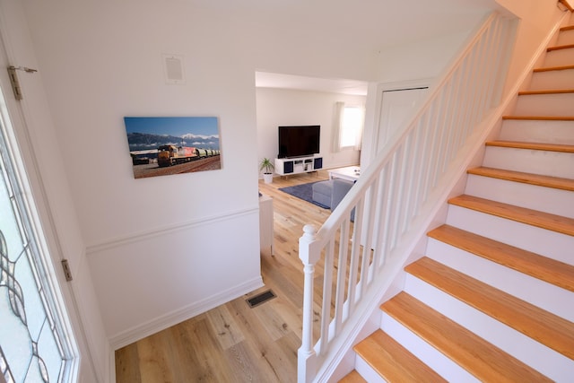 stairway featuring visible vents and wood finished floors