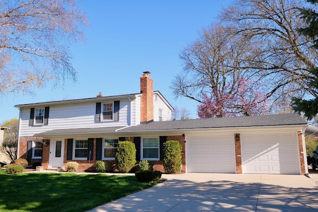 traditional home featuring a front lawn, a chimney, brick siding, an attached garage, and driveway