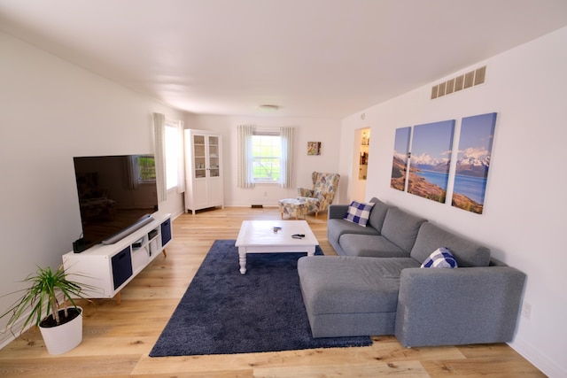 living area featuring visible vents, baseboards, and light wood-type flooring