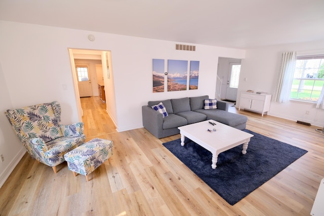 living area with visible vents, plenty of natural light, and light wood finished floors