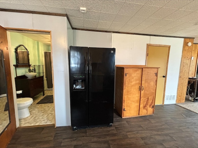 kitchen with black fridge with ice dispenser and dark wood finished floors