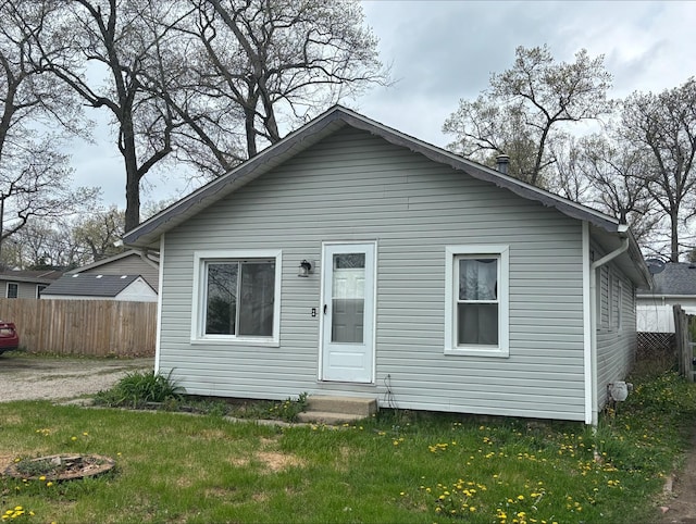back of house with fence and a yard