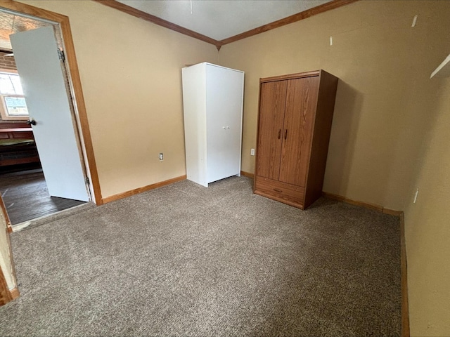 unfurnished bedroom featuring baseboards, ornamental molding, and carpet