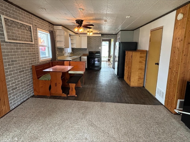 kitchen with ceiling fan, range, a sink, freestanding refrigerator, and dark carpet